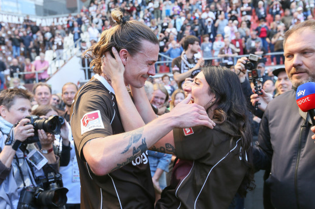 Jackson Irvine kisses Jemilla Pir following their promotion to the Bundesliga.