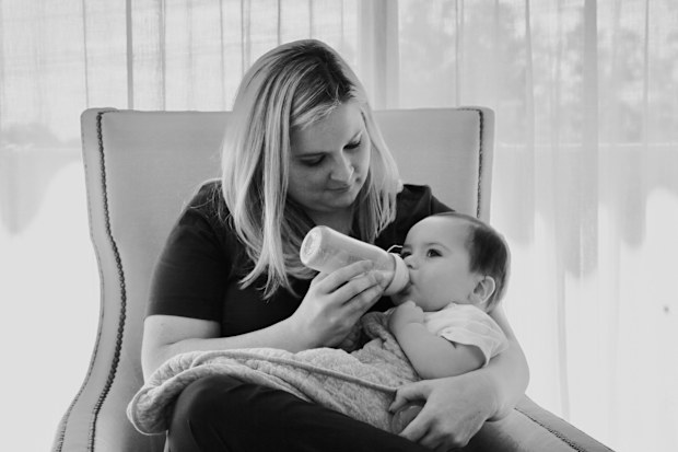 Anna Baker bottle feeds a baby.