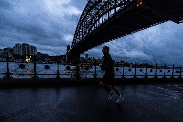 People brave the early morning rain at Dawes Point, in Sydney, 