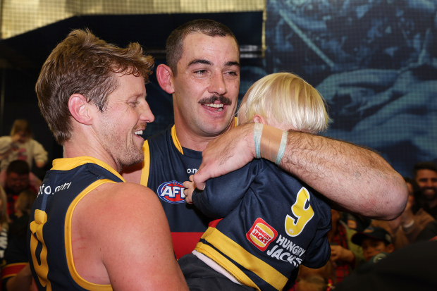 ADELAIDE, AUSTRALIA - JUNE 10: Taylor Walker of the Crows with Rory Sloane on his son after the win, 250th game and 10 goals during the 2023 AFL Round 13 match between the Adelaide Crows and the West Coast Eagles at Adelaide Oval on June 10, 2023 in Adelaide, Australia. (Photo by Sarah Reed/AFL Photos via Getty Images)