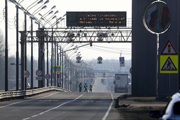 Road police stand at an empty highway to Russia at the Belarus-Russia border near Redki.