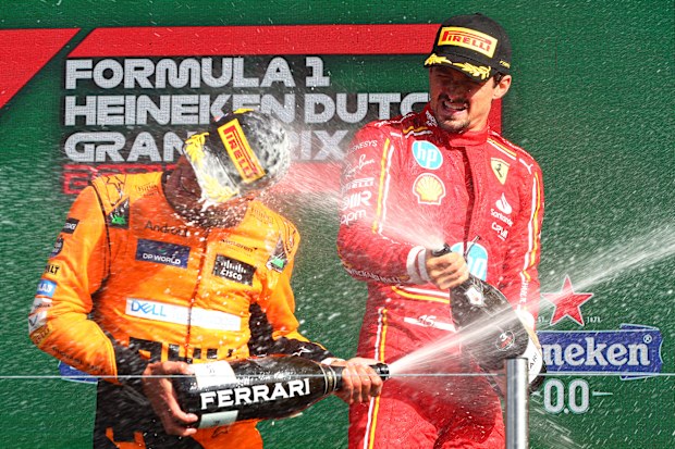Race winner Lando Norris of Great Britain and McLaren and third placed Charles Leclerc of Monaco and Ferrari celebrate in parc ferme.