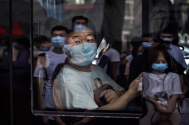 A commuter wears a mask to protect against COVID-19 as he sits on a public bus in Beijing.