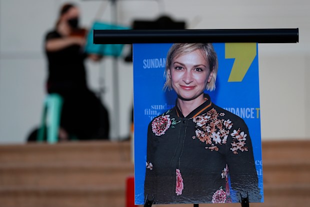 A musician plays a violin behind a photograph of cinematographer Halyna Hutchins during a vigil in her honor in Albuquerque, N.M., Saturday, Oct. 23, 2021. 