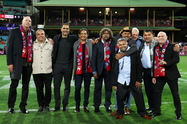 Former Swans Indigenous players pose on field before the pre-game Marn Grook Ceremony.
