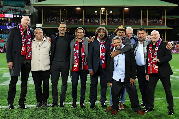 Former Swans Indigenous players pose on field before the pre-game Marn Grook Ceremony.