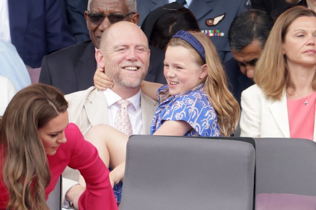Mia Tindall gives dad Mike Tindall a hug as they watch the Platinum Jubilee Pageant outside Buckingham Palace in London, Sunday June 5, 2022.