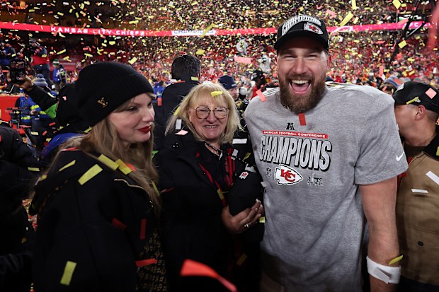 KANSAS CITY, MISSOURI - JANUARY 26: Travis Kelce #87 of the Kansas City Chiefs celebrates with Taylor Swift and mother Donna Kelce after the Chiefs defeated the Buffalo Bills 32-29 to win the AFC Championship Game at GEHA Field at Arrowhead Stadium on January 26, 2025 in Kansas City, Missouri. (Photo by Jamie Squire/Getty Images)