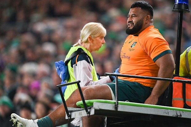 Taniela Tupou of Australia is taken from the pitch to receive medial attention.