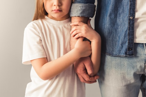 Young girl holds father's arm