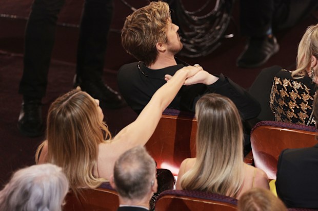 Ryan Gosling holds hands with Margot Robbie during the live telecast of the 96th Annual Academy Awards.