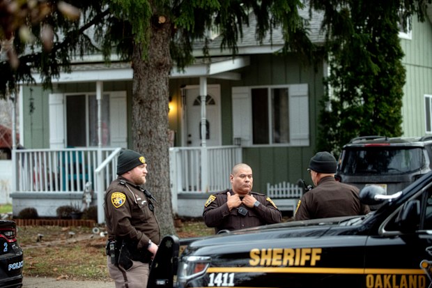 Oakland County Sheriff's Deputies survey the grounds outside of the Crumbley residence. 