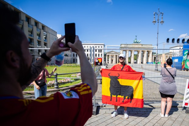 A Spain fan has his photo taken in front of the cordoned-off Brandenburg Gate.