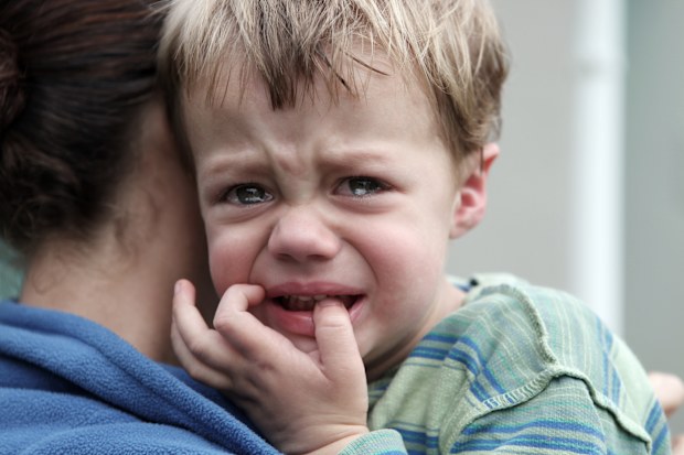 Upset little boy getting a hug. Desaturated