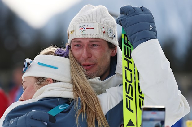 Sturla Holm Laegreid of Team Norway is embraced by Ingrid Landmark Tandrevold of Team Norway after the medal ceremony for the Men's 20km Individual on day four of the Milano Cortina 2026 Winter Olympic games at Anterselva Biathlon Arena on February 10, 2026 in Antholz-Anterselva, Italy. 
