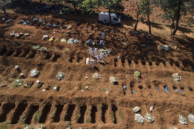 Cemetery workers in protective clothing bury a person who died of COVID-19, at the Vila Formosa cemetery in Sao Paulo, Brazil.