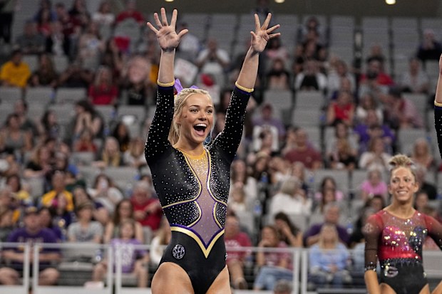 LSU's Olivia Dunne waves to fans cheering for the team as competitors warm up for the floor exercise during the NCAA women's gymnastics championships in Fort Worth, Texas, Thursday, April 18, 2024. 