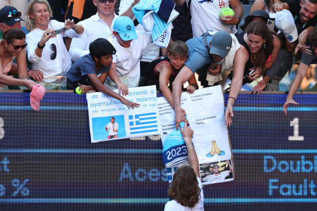 Stefano Tsitsipas embraces supporters courtside after his semi final win.