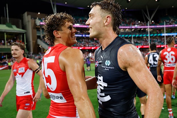 Charlie Curnow de Swans y Patrick Cripps de Blues se abrazan.