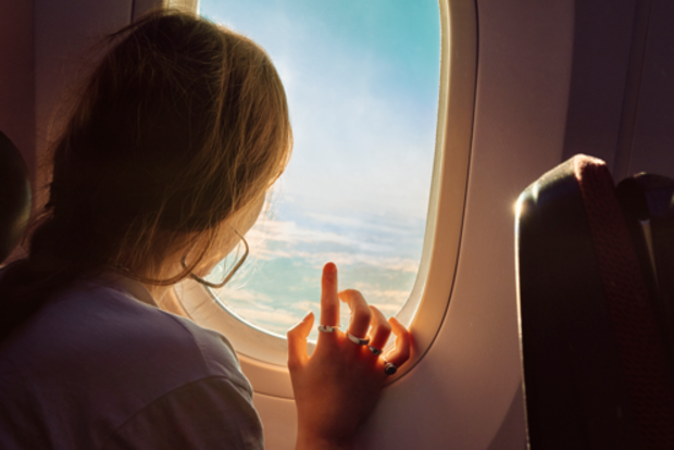 Woman looking out a plane window