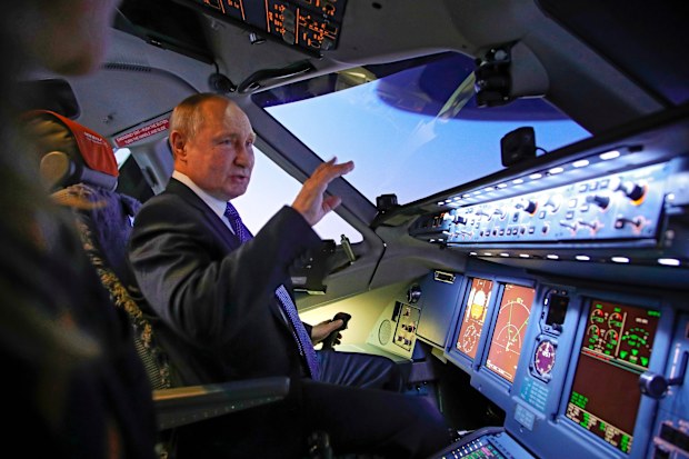 Russian President Vladimir Putin sits in the cockpit of an airplane simulator as he visits to Aeroflot Aviation School outside Moscow, Russia, Saturday, March 5, 2022 