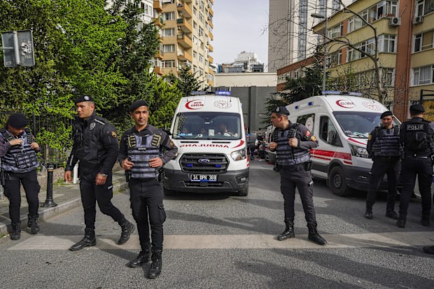 Police officers cordon off an area as firefighters and medical teams work after a fire broke out in a nightclub in Istanbul, Turkey, Tuesday, April 2, 2024 