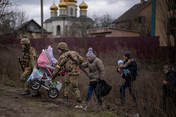 Ukrainian soldiers help a fleeing family crossing the Irpin river in the outskirts of Kyiv, Ukraine, Saturday, March 5, 2022.