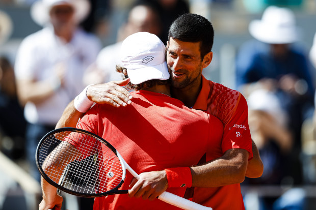 Novak Djokovic of Serbia hugs Aleksander Kovacevic after winning.