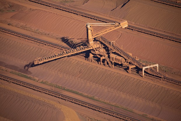 An iron ore stacker feeds stockpiles at Rio Tinto iron ore mine site in the Pilbara region of Western Australia.
