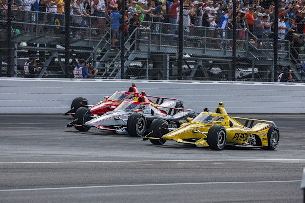 Race car driver Will Power, Scott McLaughlin, and Josef Newgarden, all of Team Penske, lead a parade lap through turn one during the 2024 Indy 500 at Indianapolis Motor Speedway. (Photo by Jeremy Hogan/SOPA Images/LightRocket via Getty Images)