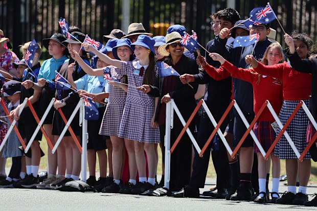 Children wave flags as King Charles III and Queen Camilla arrive for a visit on October 21, 2024 in Canberra, Australia. The King's visit to Australia will be his first as Monarch, and CHOGM in Samoa will be his first as Head of the Commonwealth.
