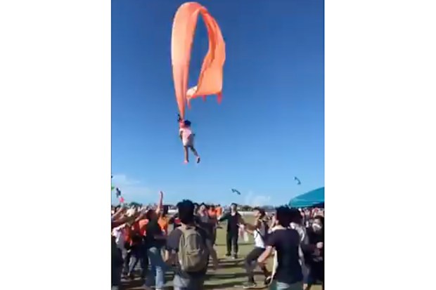 In this image made from video, a 3 year old girl is lifted into the air by a large kite during a kite festival in Hsinchu, northern Taiwan, Sunday, Aug. 30, 2020. The wind slowed down and the girl was safely recovered by adults on the ground. (Credit: Dainese Hsu)
