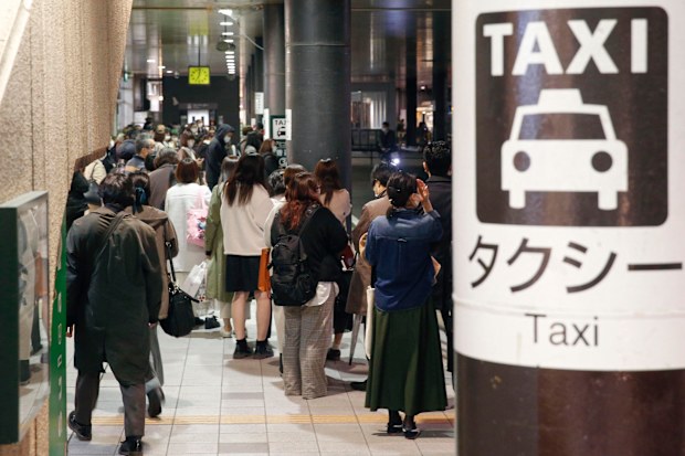 People queue up for taxi as train services are suspended following an earthquake in Sendai, Miyagi prefecture, Japan Saturday, March 20, 2021