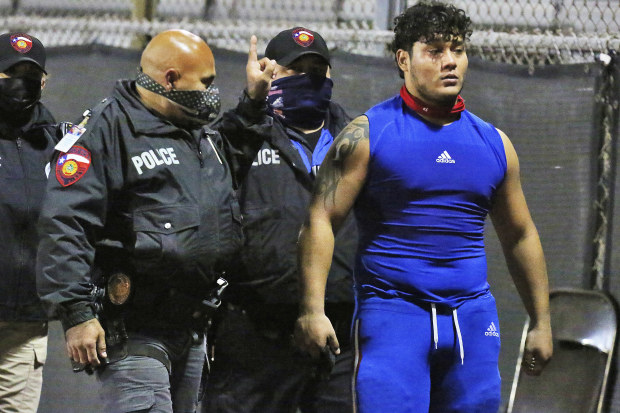 Edinburg's Emmanuel Duron is escorted out of the stadium by police after charging a referee.