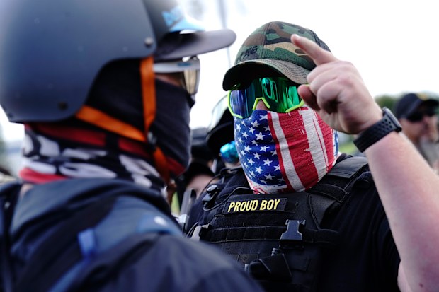 A right-wing demonstrator, right, gestures toward a counter protester as members of the Proud Boys and other right-wing demonstrators rally in Portland.