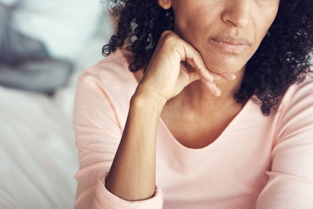 Woman looking upset with her husband in the background