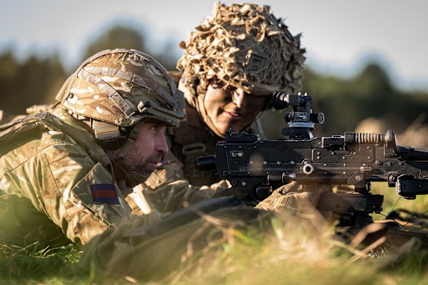 WILTSHIRE, ENGLAND - NOVEMBER 26: Prince William, Prince of Wales, Colonel of the Welsh Guards (L), with a general-purpose machine gun (GPMG), during a visit to the 1st Battalion Welsh Guards to hear how they have been transitioning from ceremonial duty back to the Field Army at Salisbury Plain on November 26, 2024 in Wiltshire, England. (Photo by Aaron Chown - WPA Pool/Getty Images)