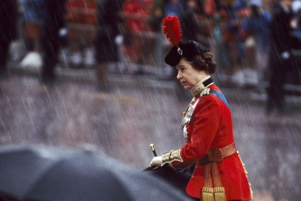 Queen Elizabeth II grimacing in driving rain at the Trooping the Colour ceremony in London on June 12, 1982.