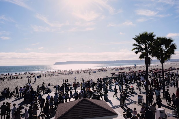 People wait for a glimpse of the return of NASA's Artemis II Friday, April 10, 2026, along the beach in Coronado, California.