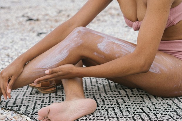 Stock photo of a woman applying sunscreen.