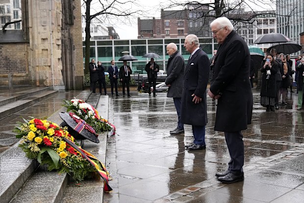 King Charles III, centre, and German President Frank-Walter Steinmeier, right, lay a wreath of flowers at St. Nikolai Memorial in Hamburg, Germany, Friday, March 31, 2023. 