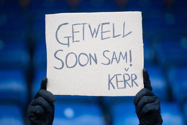 A fan holds up a banner wishing Sam Kerr to get well soon following her ACL injury.