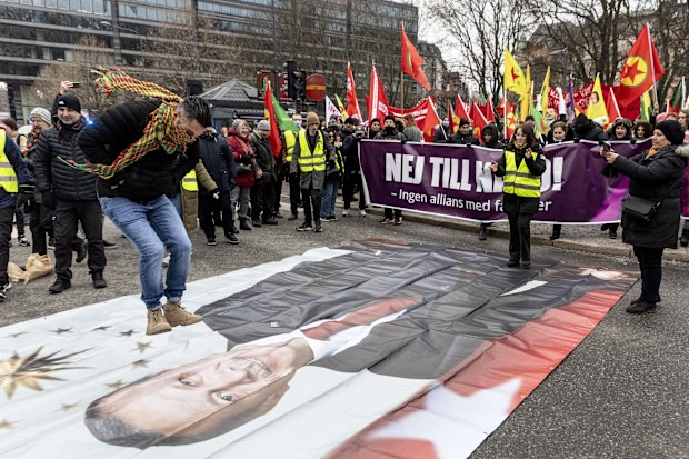 A protestor prepares to jump on a banner with the image of Turkish President Recep Tayyip Erdogan during a demonstration organised by The Kurdish Democratic Society Center in Sweden.