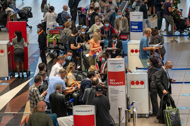 People lineup to get on the Air France flight to Paris at OR Tambos airport in Johannesburg, South Africa, Friday Nov. 26, 2021. 