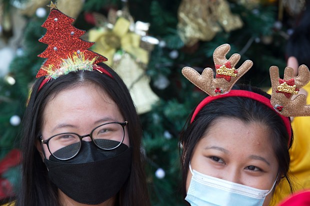 Women wearing masks to curb the spread of coronavirus, celebrate Christmas at a church in Bali, Indonesia on Friday, Dec. 24, 2021. 