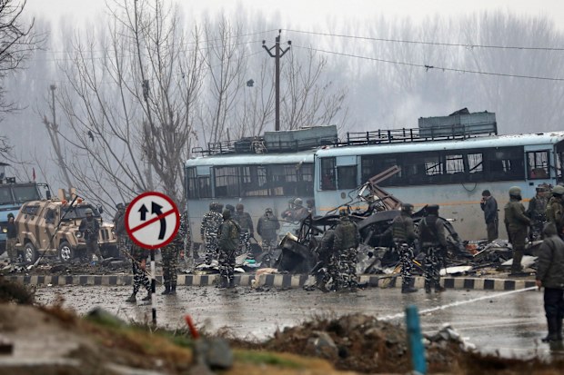 Indian paramilitary soldiers stand by the wreckage
