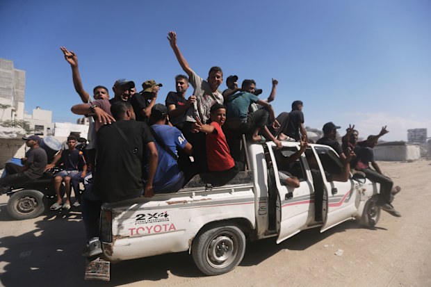 Displaced Palestinians walk along the coastal road as they move in the direction of Gaza City,