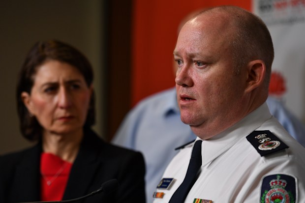NSW Premier Gladys Berejiklian looks on as RFS Commissioner Shane Fitzsimmons speaks to the media during a press conference at Rural Fire Service (RFS) Headquarters in Sydney, Sunday, January 5, 2020. (AAP Image/Paul Braven) 
