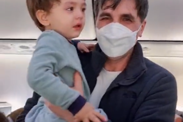 Parikshit Balochi holding the crying toddler on board the passenger flight.