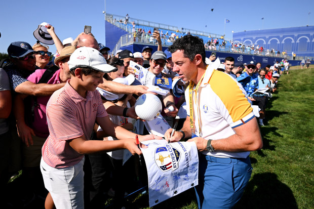 Rory McIlroy of Team Europe signs autographs for fans.
